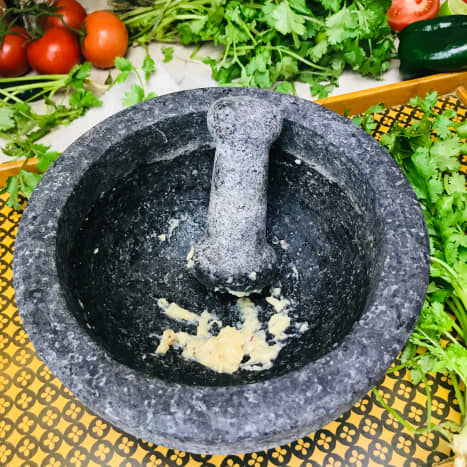 Mash the garlic in a molcajete until it is creamy with very few lumps.