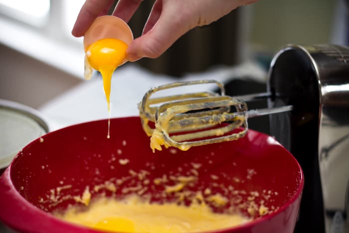 Adding eggs into your cake batter.