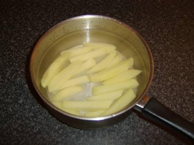 Parboil the chipped potatoes in water