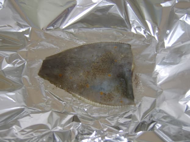 Plaice is seasoned and baked in foil with a little butter
