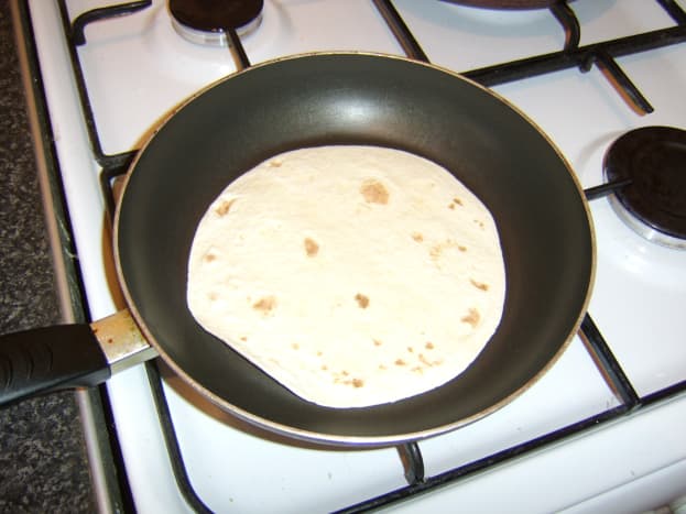 The tortilla wraps are heated in a dry frying pan