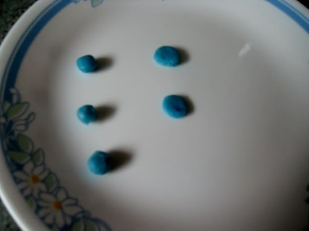 Make the iris by flattening pea-sized balls of blue mixture