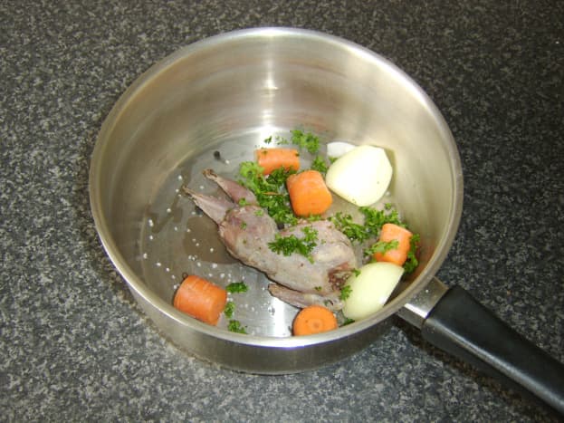 Quail, chopped vegetables and seasoning are added to a large pot