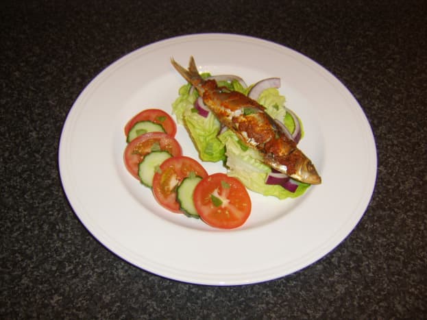 Red pesto sauce is rubbed on to the sardine before it is baked and served with a simple salad.