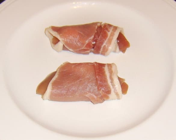 Partridge breasts are carefully wrapped in bacon