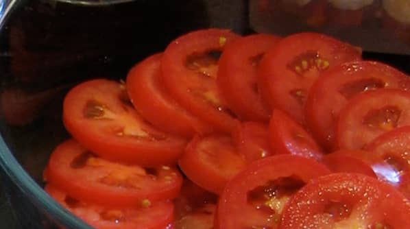 Sliced tomato layer in the casserole dish.