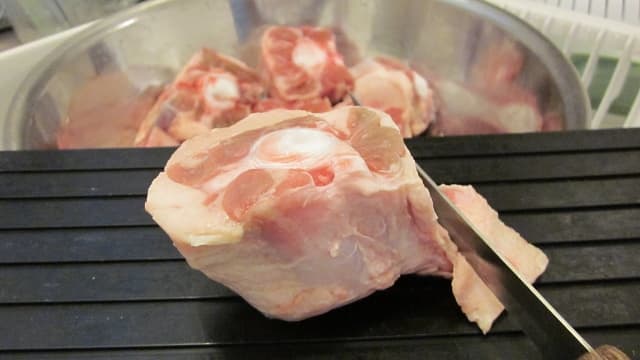 Using a sharp knife, trim any excess fat from the oxtail before seasoning.