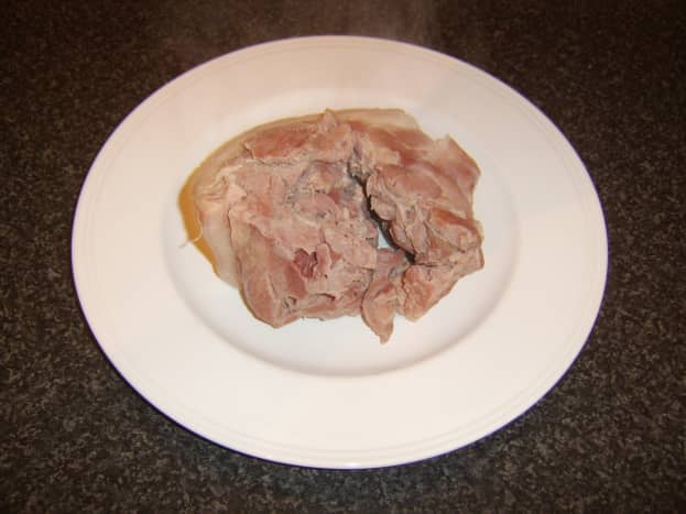 Cooked ham is removed to a plate to cool