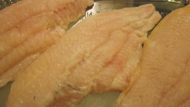Raw catfish fillets are cleaned and ready for savory seasonings.