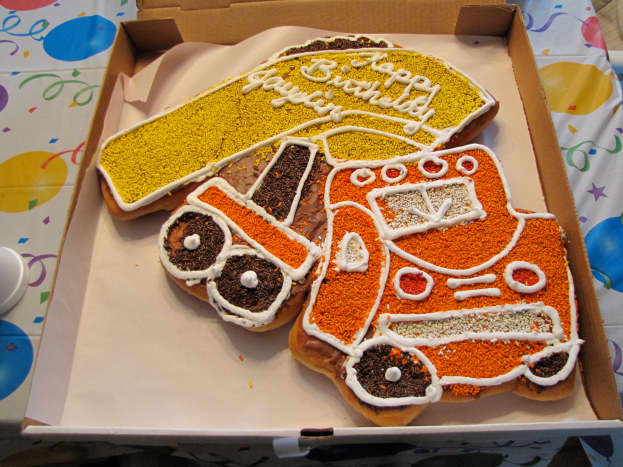 This birthday donut cake is shaped like a dump truck.