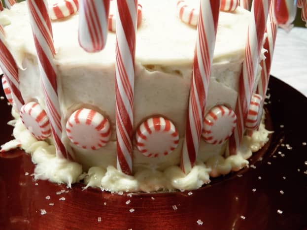 After icing, put candy canes around the cake about 1-2 inches apart.  Then put peppermints inbetween.