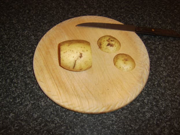 Two end slices are cut from baking potato