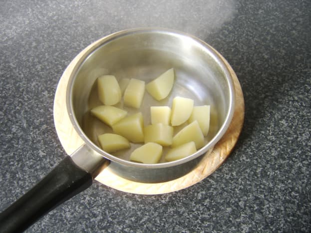 Boiled potatoes are left to steam and cool