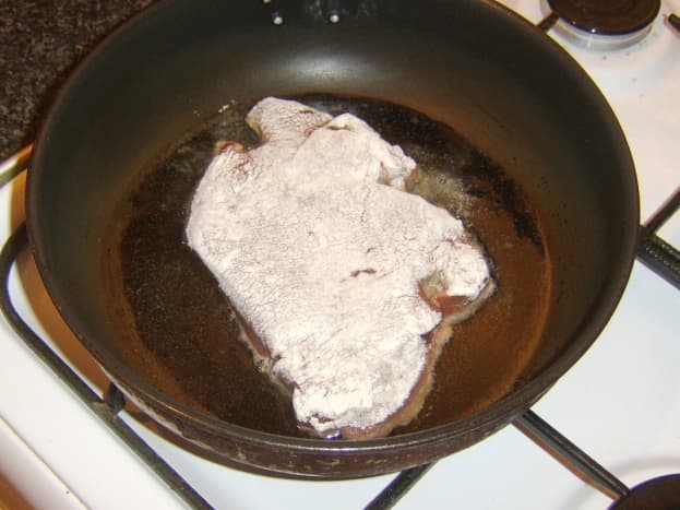 Floured ox liver is added to frying pan.