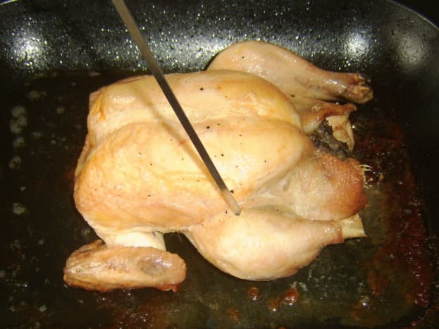 Testing roast chicken for doneness