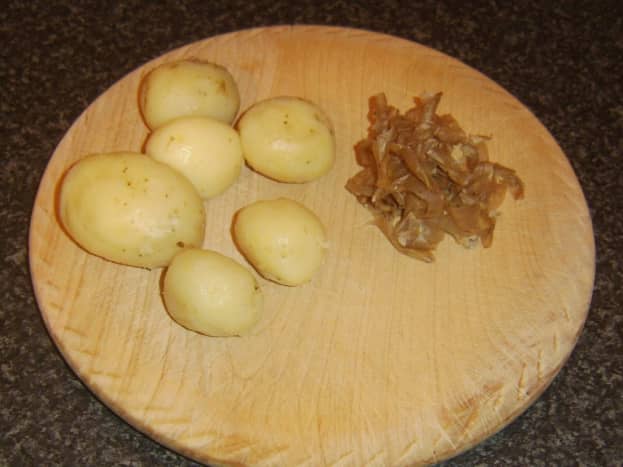 Boiled and cooled potatoes are peeled for deep frying
