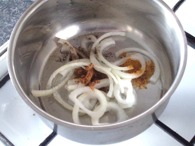 Onion and seasonings are added to pot with oil