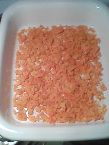 Step 2: Layer half of the crushed Doritos in the baking dish