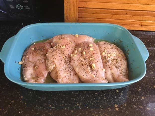 First, marinate the chicken. Rub in salt and pepper into the chicken. Combine 3/4 cup of the lemon juice, olive oil, 3 cloves garlic, 8 sprigs tarragon, and some salt and pepper additional into a casserole dish or some other shallow vessel. 