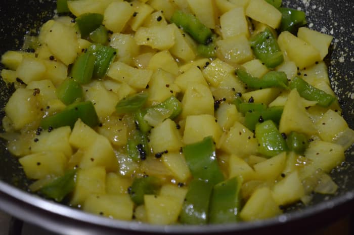 Step one: Stir-fry the potato and capsicum in mustard seeds tempering.