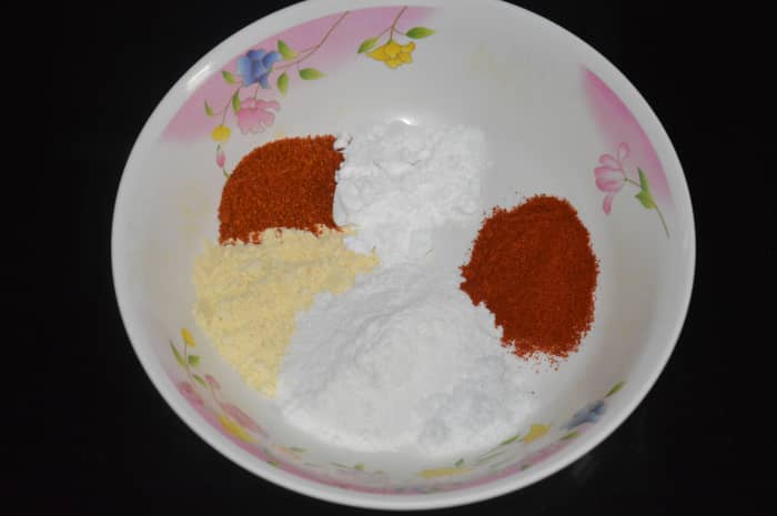 Step one: Put rice flour, corn flour, red chili powder, rasam powder, gram flour, and salt in a mixing bowl. Dry-mix them.