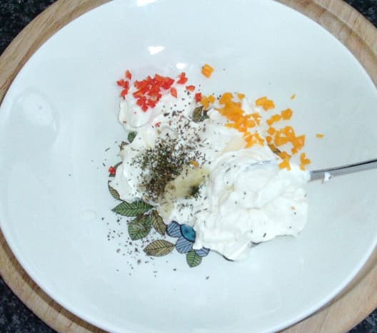 Herbs and spices are added to cream cheese