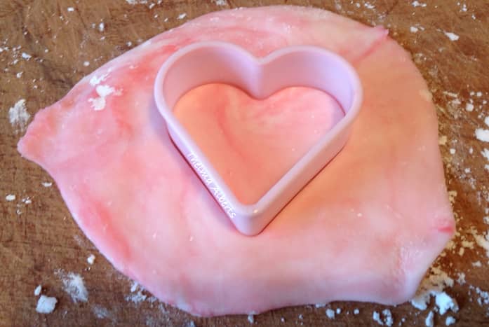 Creating a heart out of colored marzipan with the use of a heart cookie cutter