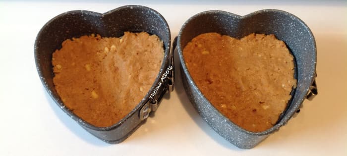 Biscuits and peanut butter paste inside the heart springform.