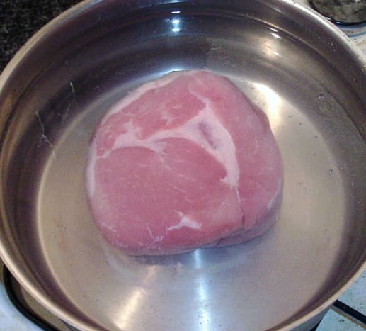 Ham is placed in a large pot of cold water