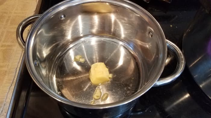 Melt some butter in a large pot on the stove over medium heat.