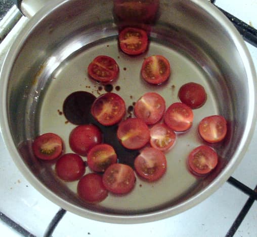 Tomato sauce ingredients are added to a small saucepan