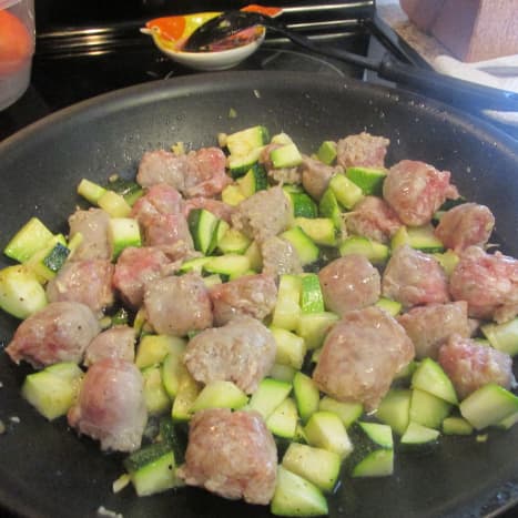 Garlic, zucchini and sausage cooking in the pan.