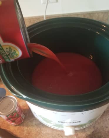 Pour tomato juice into a crock-pot. Add in tomato paste. Cook on high.