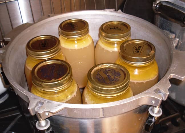 The usual canner holds 7 quart jars - 6 around the outside, and 1 in the center. We had only six full jars for this load. Note the wire rack in the bottom of the canner, which holds the jars off the bottom.