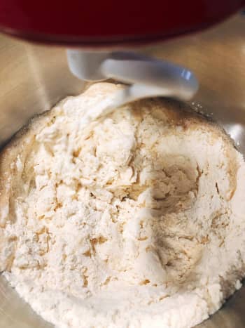 In a mixing bowl, combine the yeast mixture and the dry ingredients. Mix at a lower speed. 