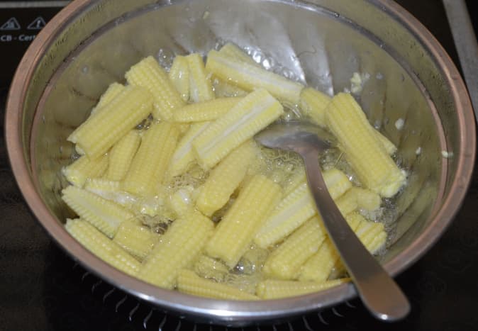 Parboil the baby corn with some salt and water. Set aside.