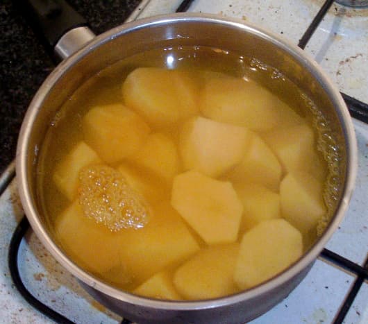 Potatoes are boiled in water with turmeric and salt