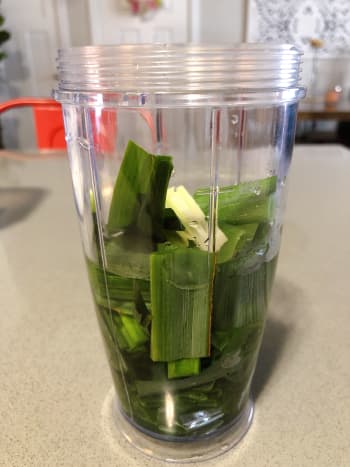 Take the pandan leaves and place them into a blender. Pour in some water and blend until fine. 