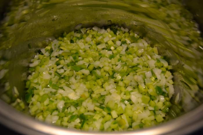 Cook diced vegetables in butter in a large pot. This photo shows the veggies during the cooking process&mdash;but they're not ready yet.
