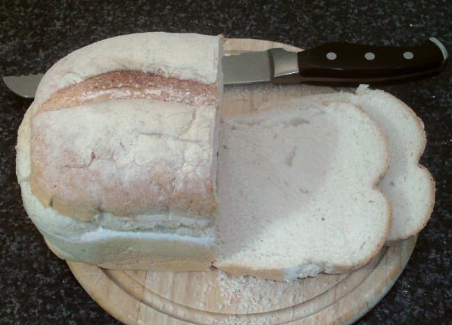 Slices are cut from a farmhouse loaf