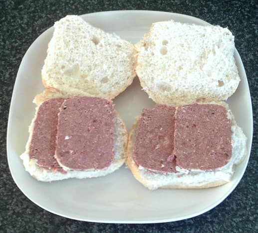 Slices of corned beef are laid on cut open bread rolls