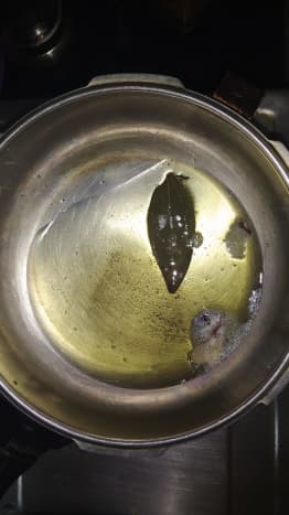 Heat oil in a cooker and add cloves, bay leaves, and star anise.
