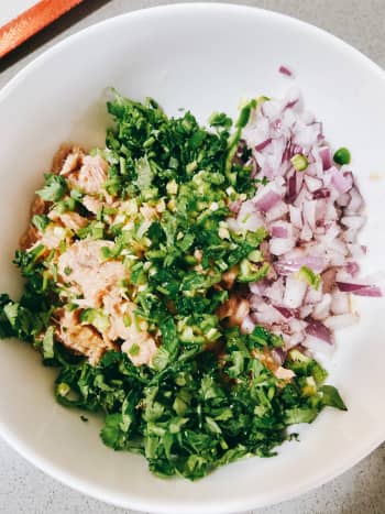 In a bowl, combine the tuna, chopped onion, serrano pepper, red onion, salt, pepper, lime juice, and mayonnaise. 