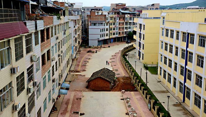 A new road and new buildings on either side and a development almost complete - but for the obstacle in the middle - the tiny nail house of Nanning