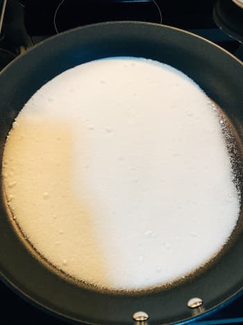 Pour one cup of white granulated sugar into a prepared pan. Heat up the sugar on low heat. 