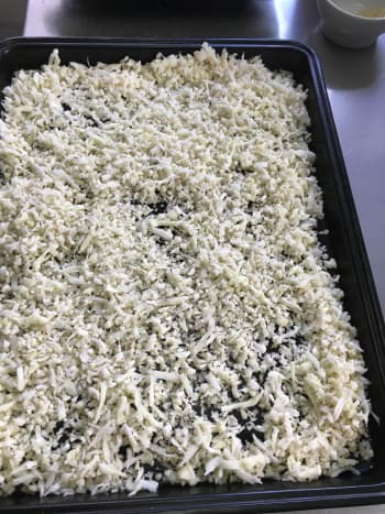 Spread grated cauliflower on baking sheet.