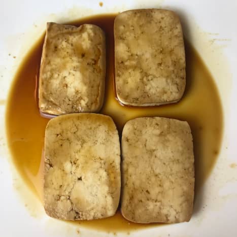 Lay the tofu slices out flat either on a plate or in a bag, then add the shoyu sauce. Let them marinate while you prepare the remaining ingredients, and flip the tofu pieces after about 12 minutes. You can also marinate them overnight.
