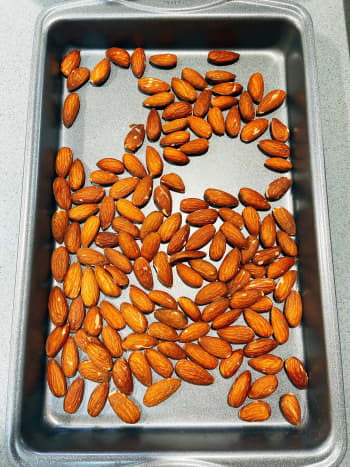 Roast the almonds on a pan in the oven for 10 minutes or until the oil has emerged on the skin. Set aside.