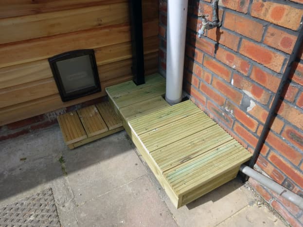 Decking fitted to base, last peice locking platform in place around the rain water down pipe.
