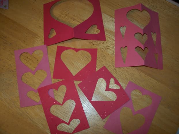 Save the papers you cut the hearts out of.  You can paste them on the outsides and insides of your cards.